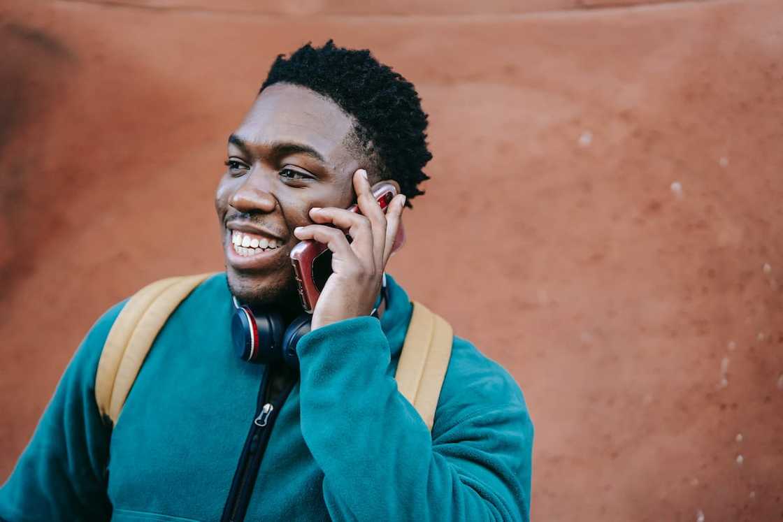 A happy man in a blue jacket making a phone call A happy man in a blue jacket making a phone call