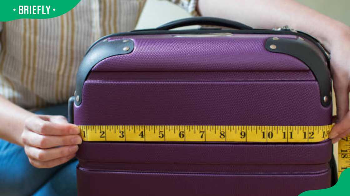 A woman measuring suitcase