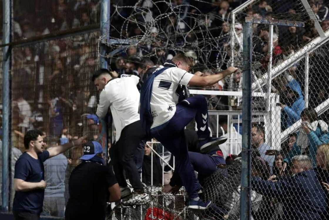 Spectators of a Boca Juniors soccer match against Gimnasia y Esgrima react after Argentina police used tear gas to break up violent clashes that began outside the stadium in La Plata but then entered the venue, leaving one person dead Spectators of a Boca Juniors soccer match against Gimnasia y Esgrima react after Argentina police used tear gas to break up violent clashes that began outside the stadium in La Plata but then entered the venue, leaving one person dead