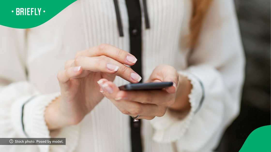 A woman typing on her phone. A woman typing on her phone.
