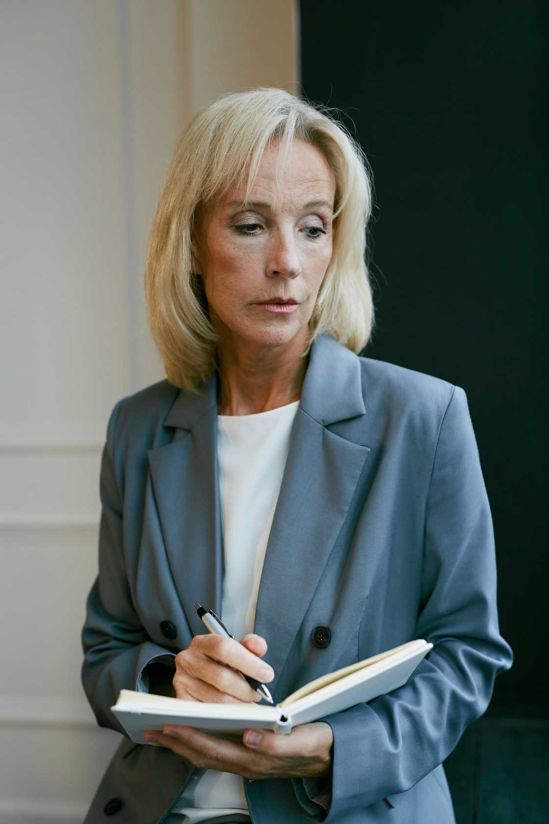 An older woman hold a notepad.