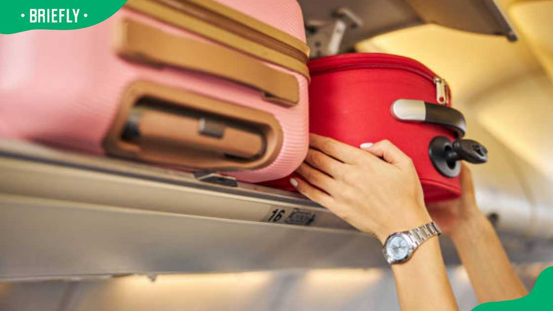 A traveller laying down a carry-on baggage