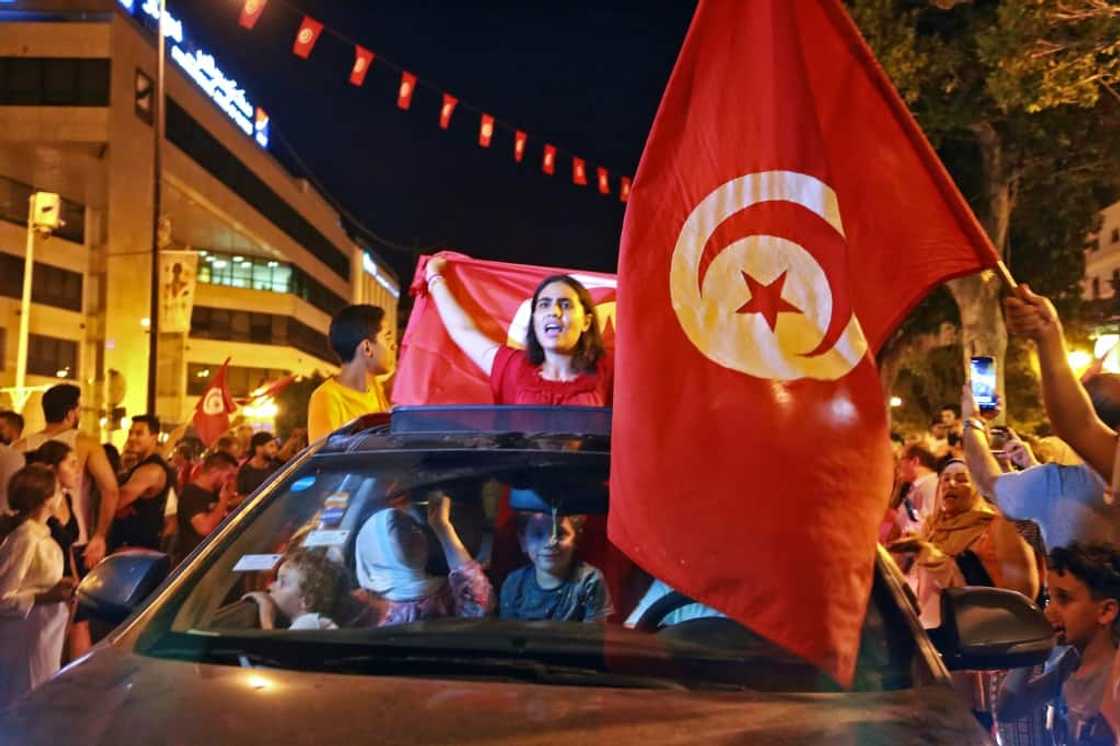 Supporters of Tunisia's President Kais Saied rejoice on Habib Bourguiba Avenue in the capital Tunis after the projected outcome of a constitutional referendum was announced