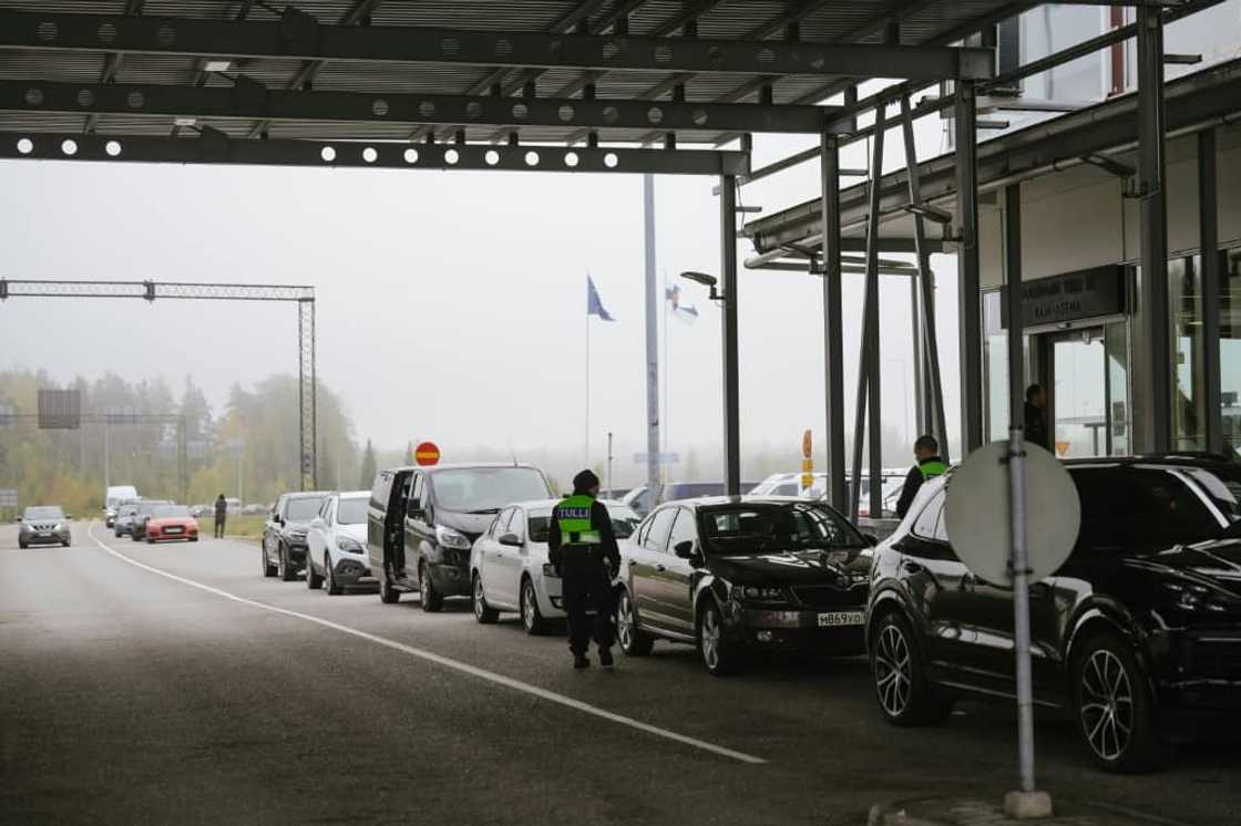 Dozens of cars and buses with Russian licence plates are lined up at the border