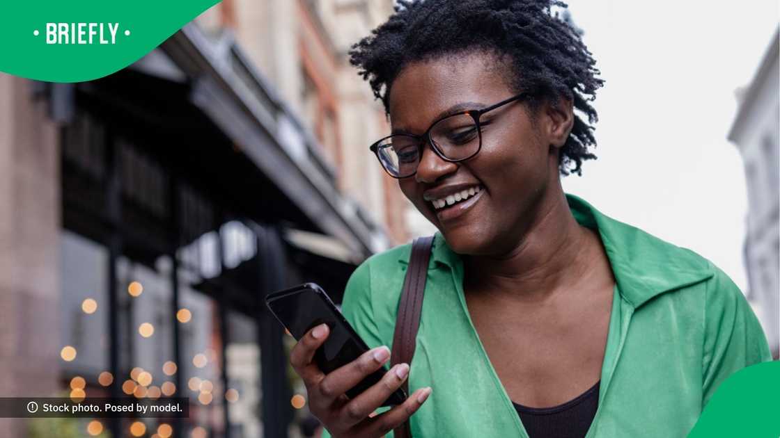 A woman laughing at her phone.