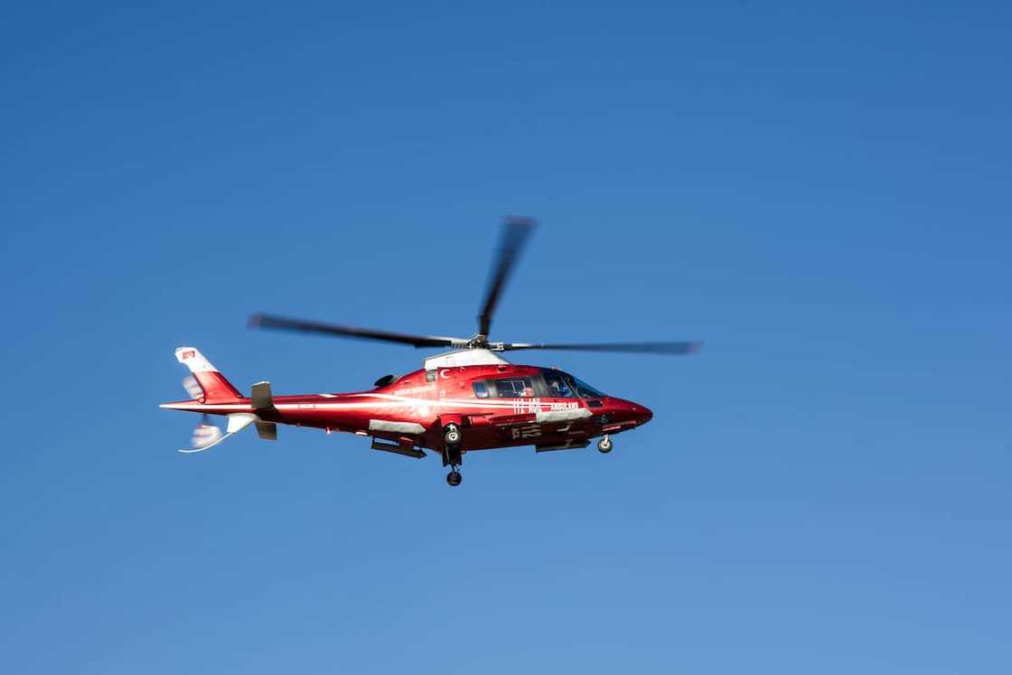 A red and white helicopter flying in the blue sky A red and white helicopter flying in the blue sky