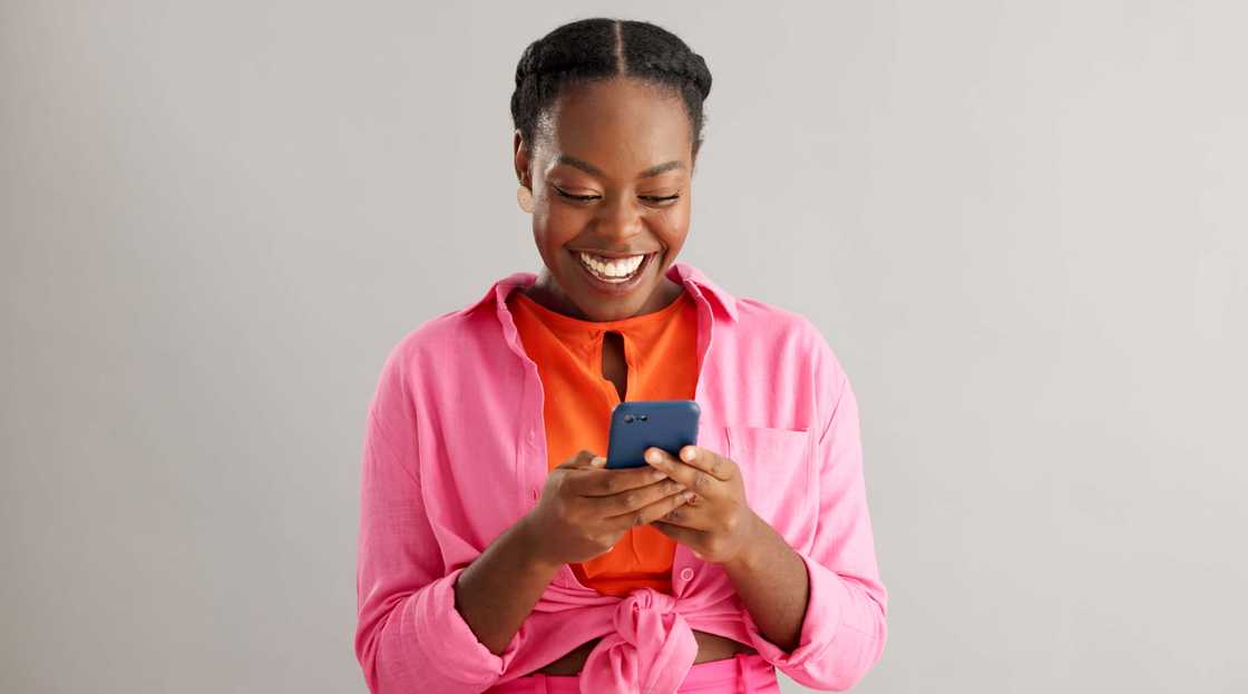 Woman smiling at her phone. Woman smiling at her phone.