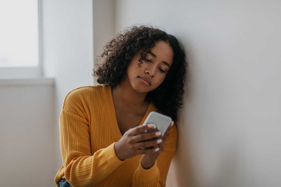 A lady sits on the floor as she types