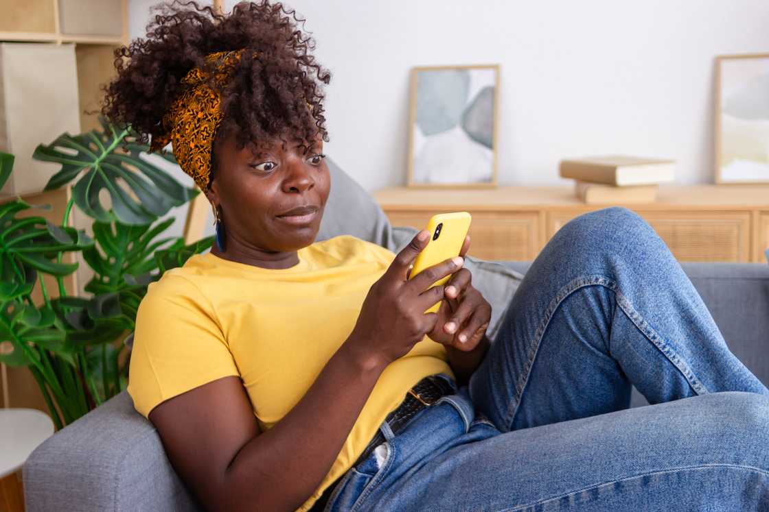 A shocked woman looking at her phone.