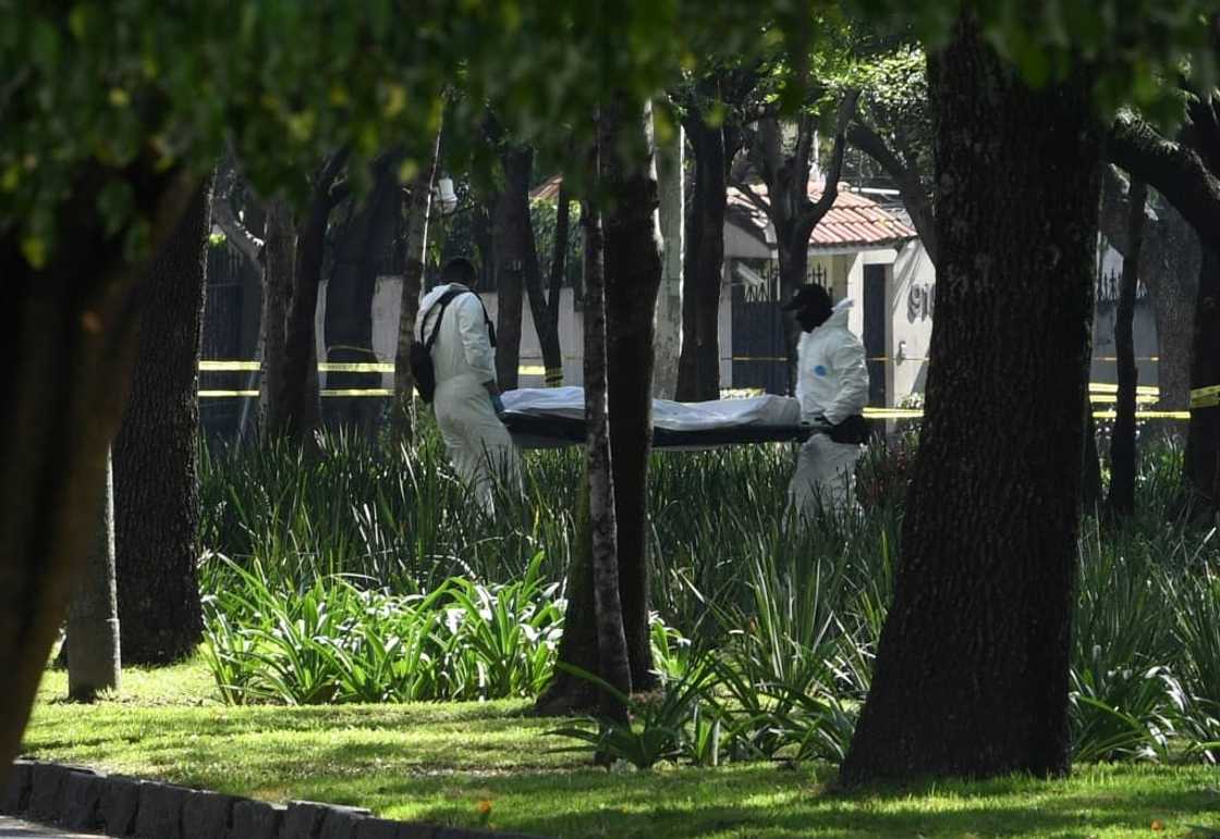 Forensic experts remove a corpse after Mexico City's Public Security Secretary Omar Garcia Harfuch was attacked in Mexico City on June 26, 2020