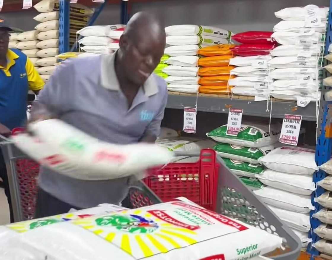 A man packing household essentials during a trolley dash in a video. A man packing household essentials during a trolley dash in a video.