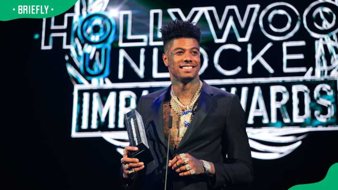 Rapper Blueface posing with an award Rapper Blueface posing with an award