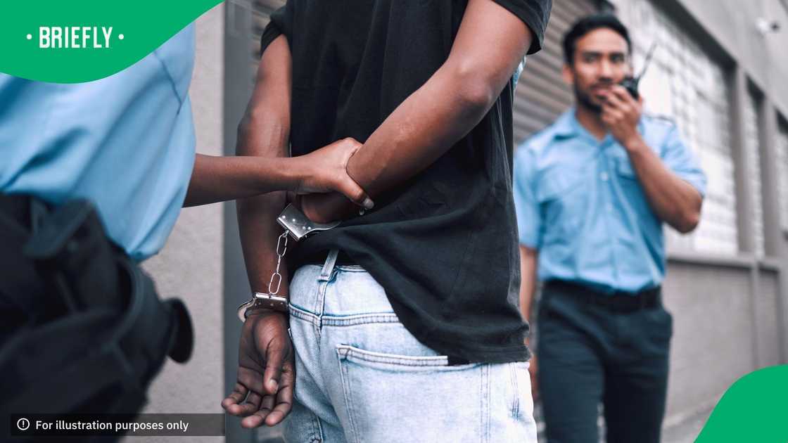 Criminal, handcuffs, and arrest with a security officer or radio at the property for protection or safety. Police, patrol, and crime, and a guy going to jail for robbery, drugs, or stealing in the street with tech Criminal, handcuffs, and arrest with a security officer or radio at the property for protection or safety. Police, patrol, and crime, and a guy going to jail for robbery, drugs, or stealing in the street with tech
