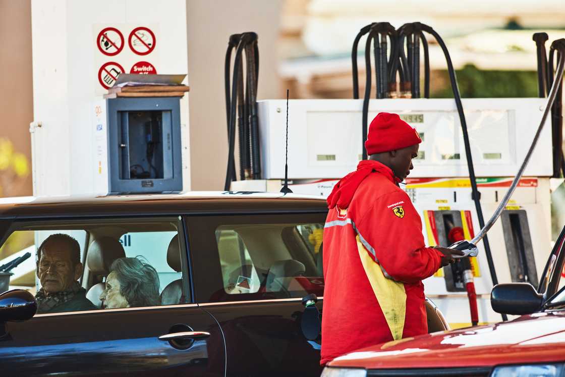 A petrol attendant was snapped refuelling a car of two elderly people A petrol attendant was snapped refuelling a car of two elderly people