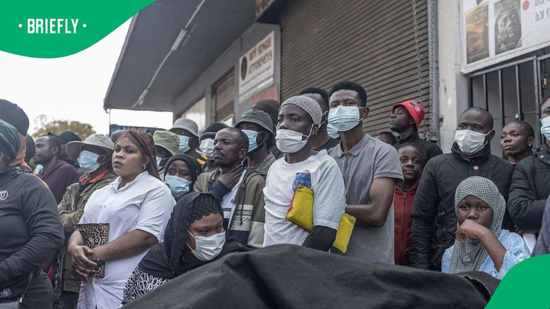Foreign nationals stand by as they watch protestors from the anti-illegal immigration group, March and March Movement hold placards and chant slogans during a demonstration in Durban, on September 10, 2026 Foreign nationals stand by as they watch protestors from the anti-illegal immigration group, March and March Movement hold placards and chant slogans during a demonstration in Durban, on September 10, 2026