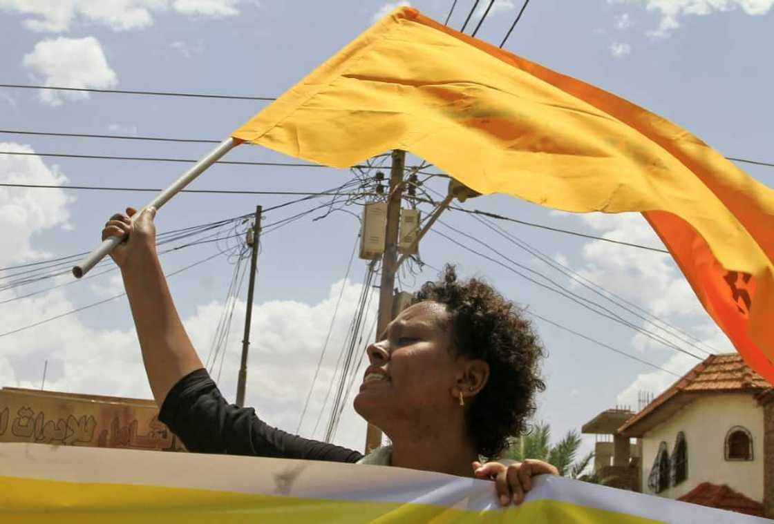 A Sudanese woman raises a flag during a pro-democracy rally in the capital Khartoum A Sudanese woman raises a flag during a pro-democracy rally in the capital Khartoum