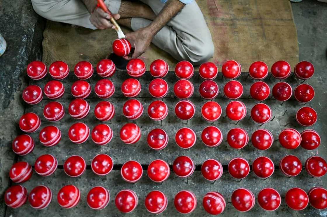 In this photograph taken on September 14, 2023, a worker polishes cricket balls at a workshop in Meerut in India's northern state of Uttar Pradesh