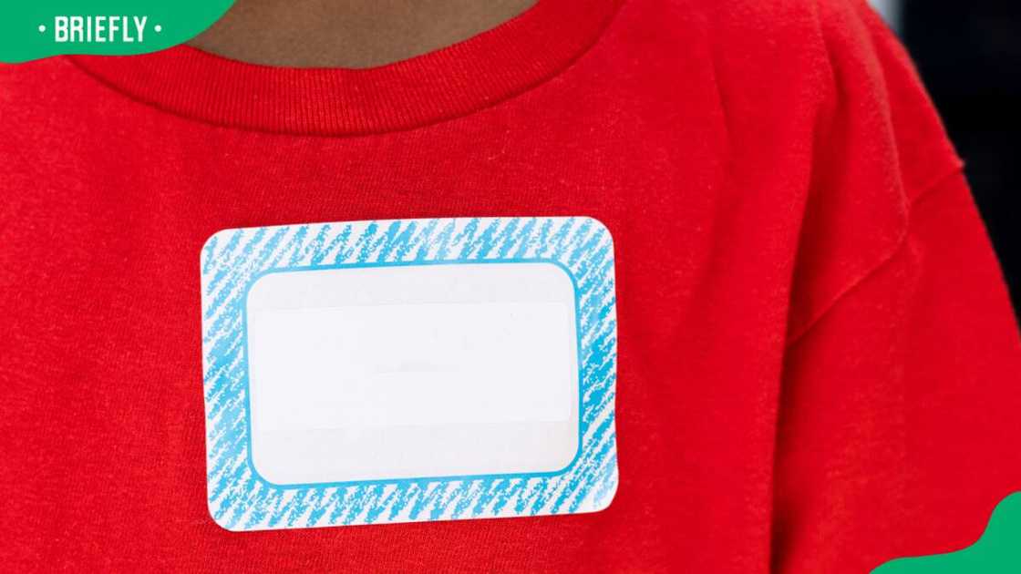 A young boy wearing red t-shirt with a sticker