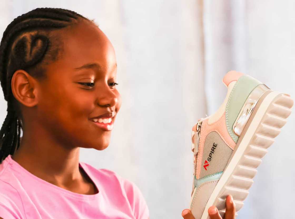 Girl holding Nspire sneaker Girl holding Nspire sneaker