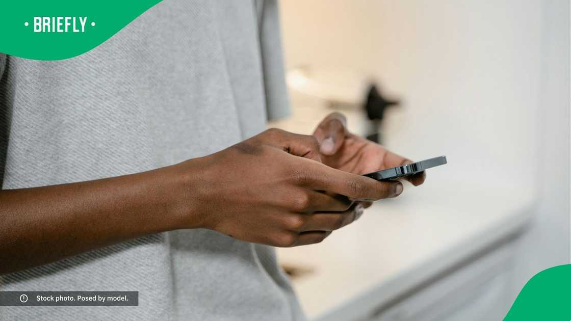 A man typing on his phone. A man typing on his phone.