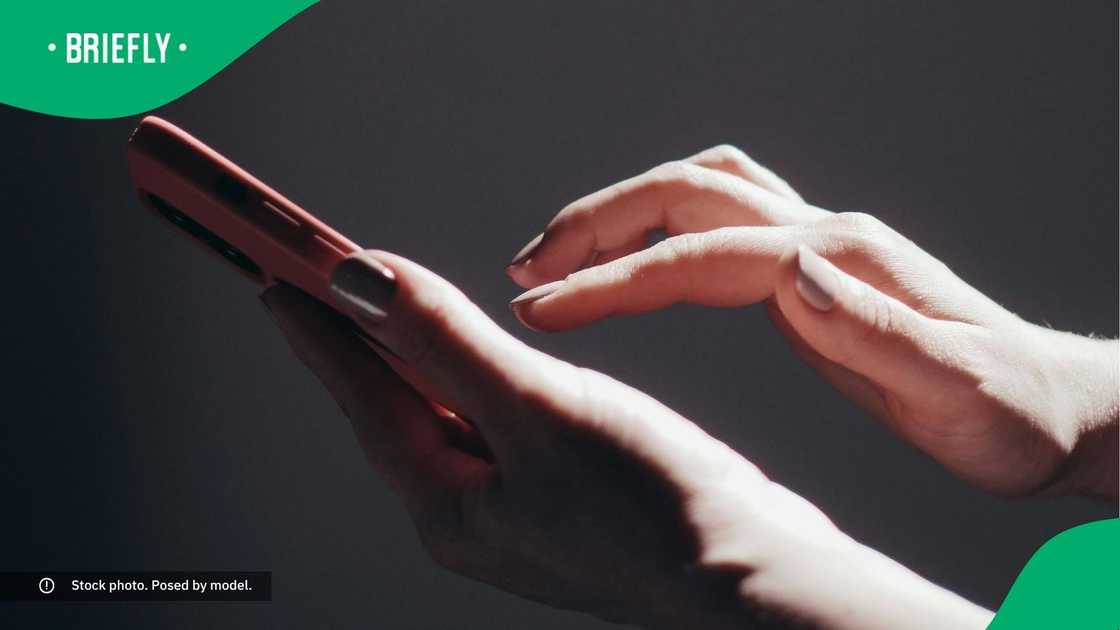 A woman typing on her phone. A woman typing on her phone.