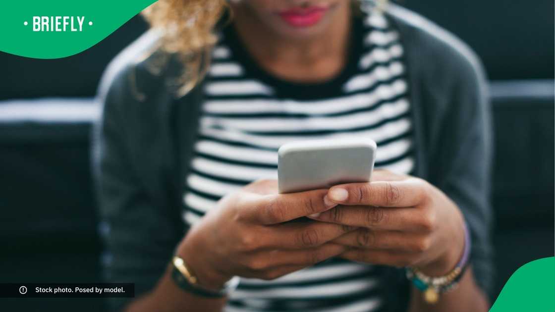 A woman typing on her phone. A woman typing on her phone.
