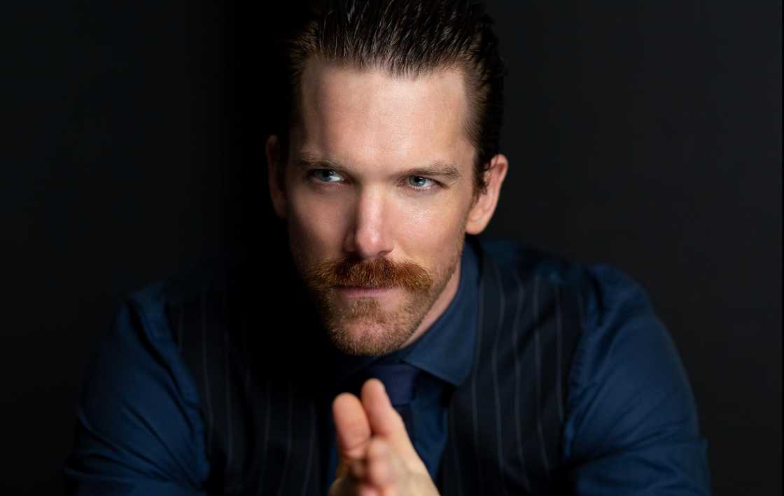 Victor Zinck Jr in a dark blue shirt against a black background