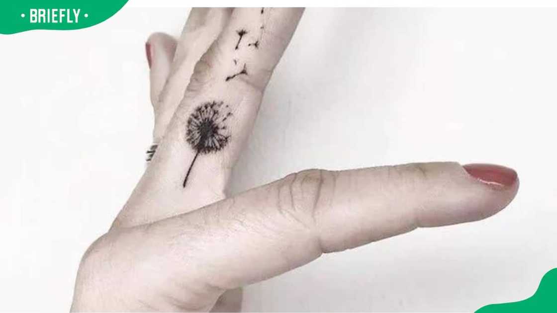 A detailed dandelion finger tattoo A detailed dandelion finger tattoo