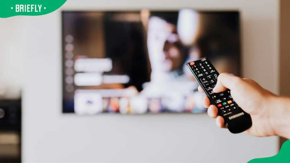 A person pressing the button of a remote control. A person pressing the button of a remote control.