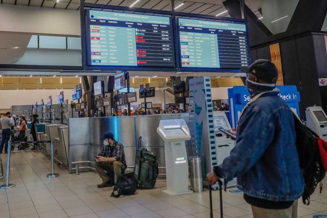 A passenger looking at an electronic flight notice board displaying cancelled flights A passenger looking at an electronic flight notice board displaying cancelled flights