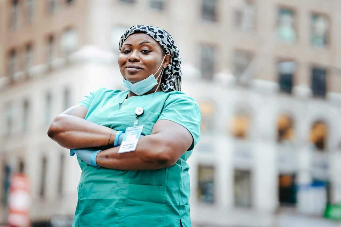 A smiling female medic in green scrubs A smiling female medic in green scrubs