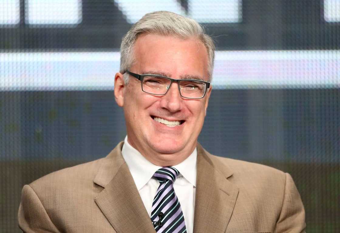 Keith Olbermann speaks onstage in a tan suit. Keith Olbermann speaks onstage in a tan suit.