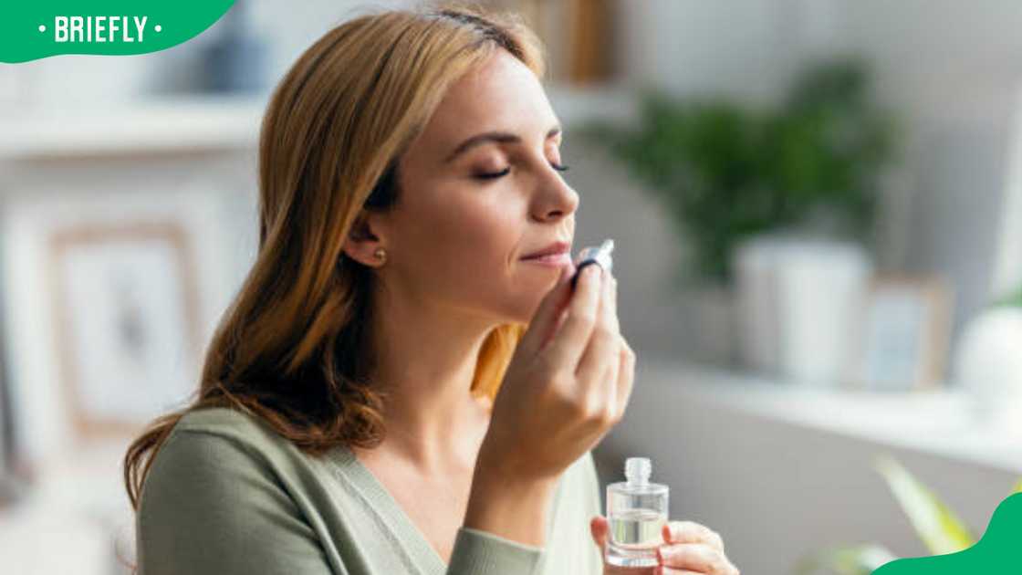 A lady smelling cologne