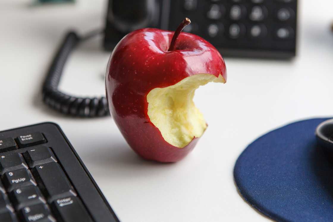 a half-eaten apple on office desk