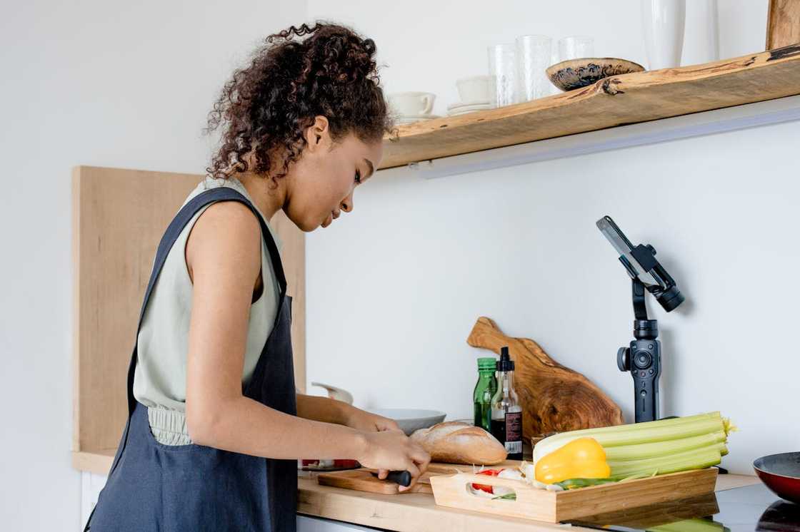 A young woman preparing food in a bright kitchen. A young woman preparing food in a bright kitchen.