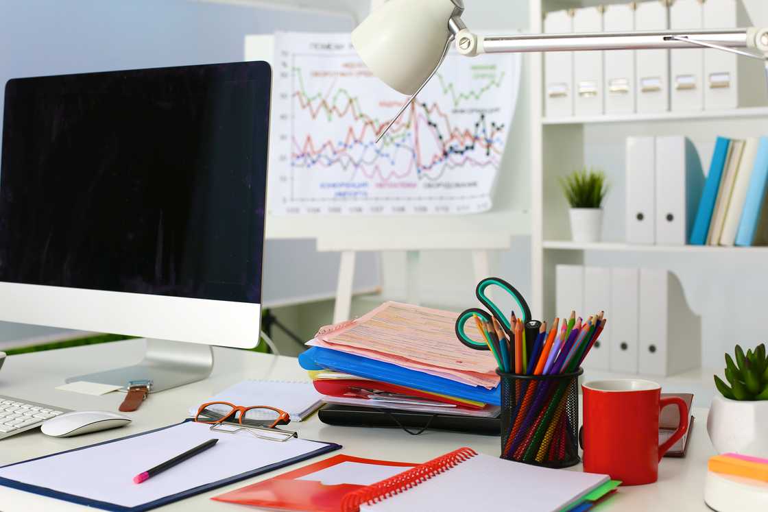 A computer and files on an office desk