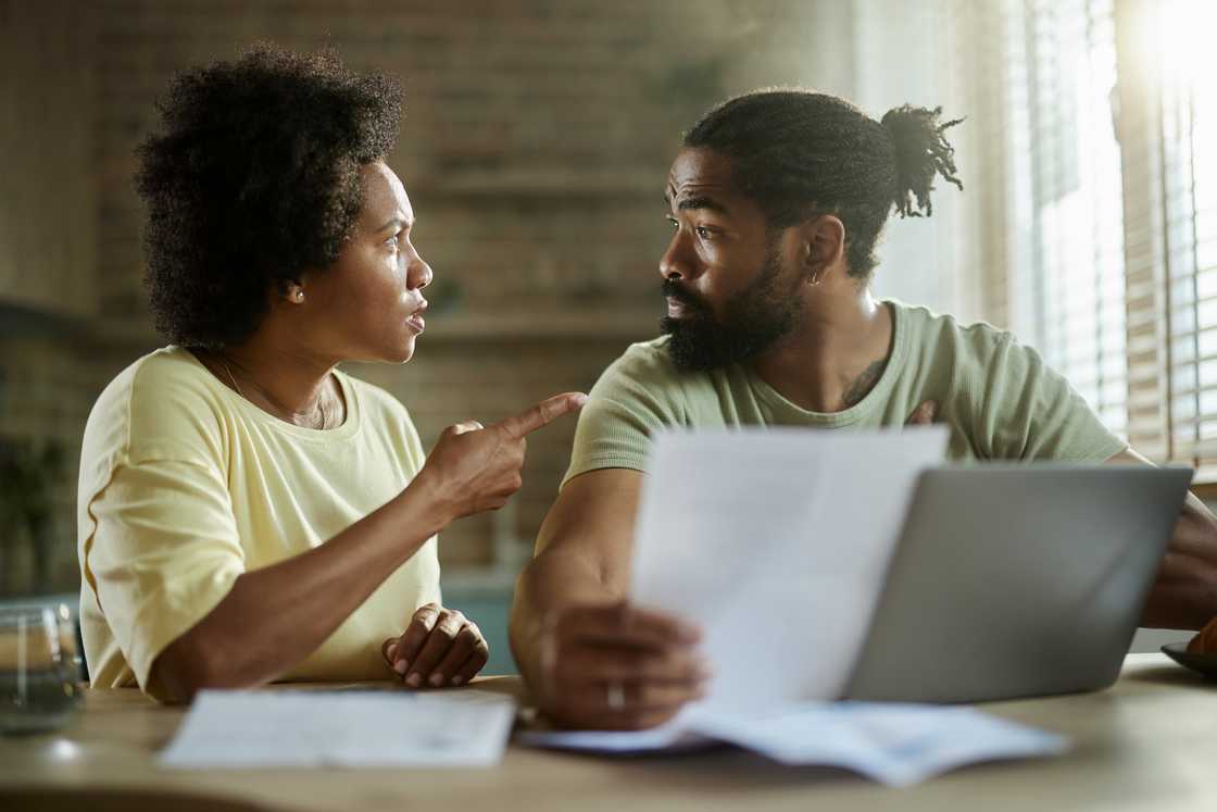 A woman confronting her boyfriend in a home workstation.