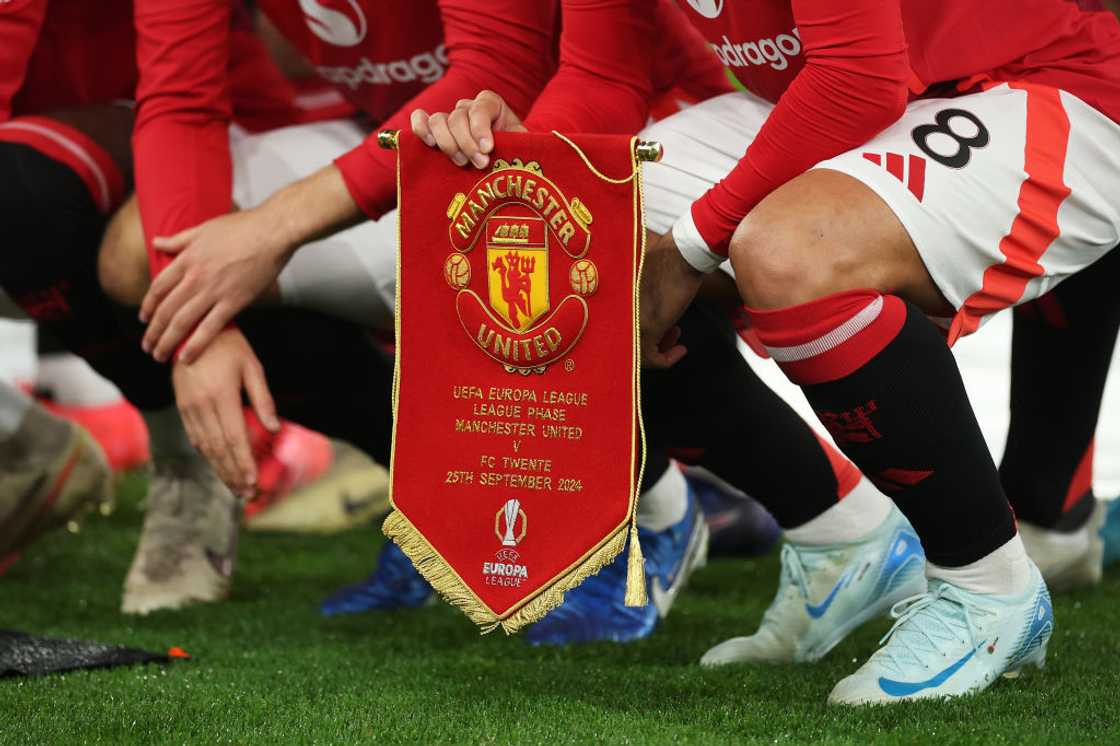 A detailed view of the match pennant as players of Manchester United pose for a team photograph A detailed view of the match pennant as players of Manchester United pose for a team photograph