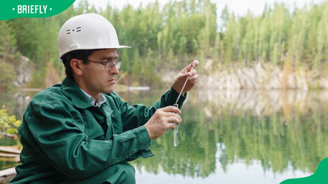 A geologist at a lake near a folded quarry A geologist at a lake near a folded quarry