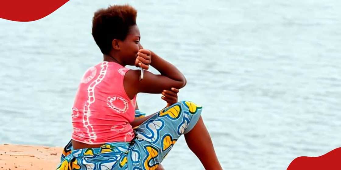 Photo of African woman looking at the sea.