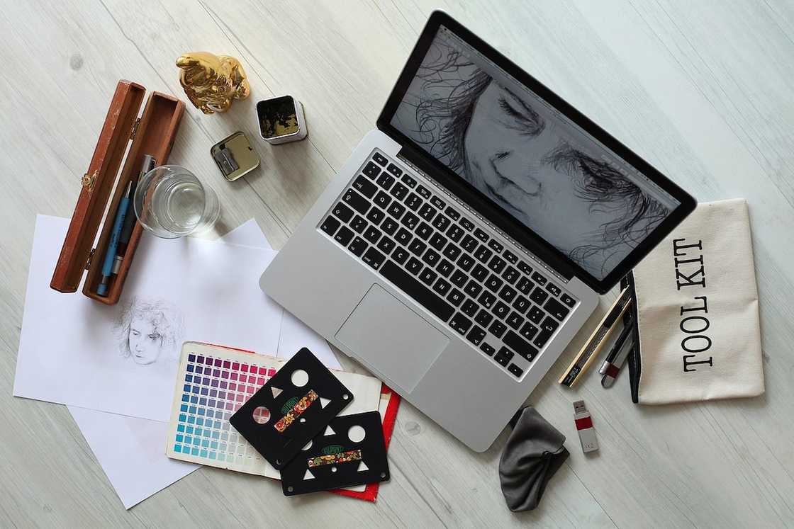 A laptop and various tools and cards on a workspace