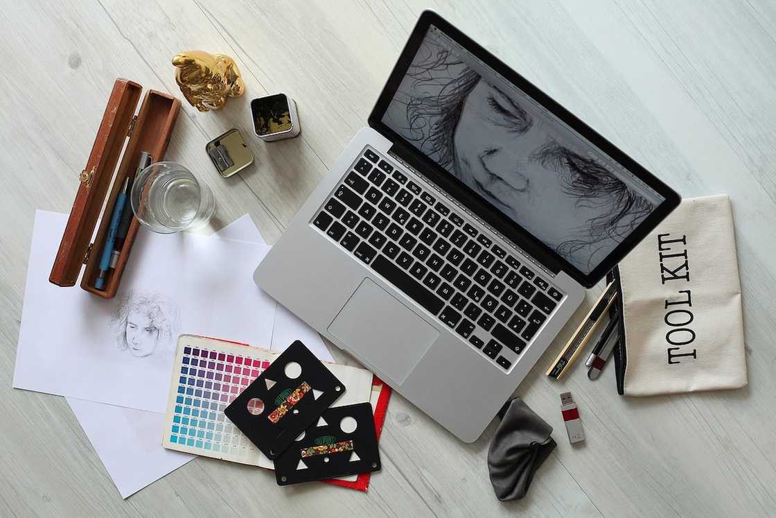 A laptop and various tools and cards on a workspace A laptop and various tools and cards on a workspace