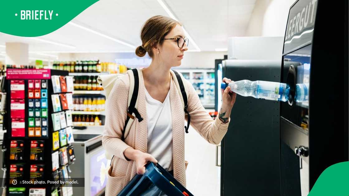 A young woman recycling bottles at a supermarket. A young woman recycling bottles at a supermarket.