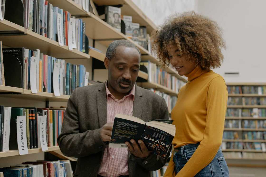 A student and a teacher in the library A student and a teacher in the library