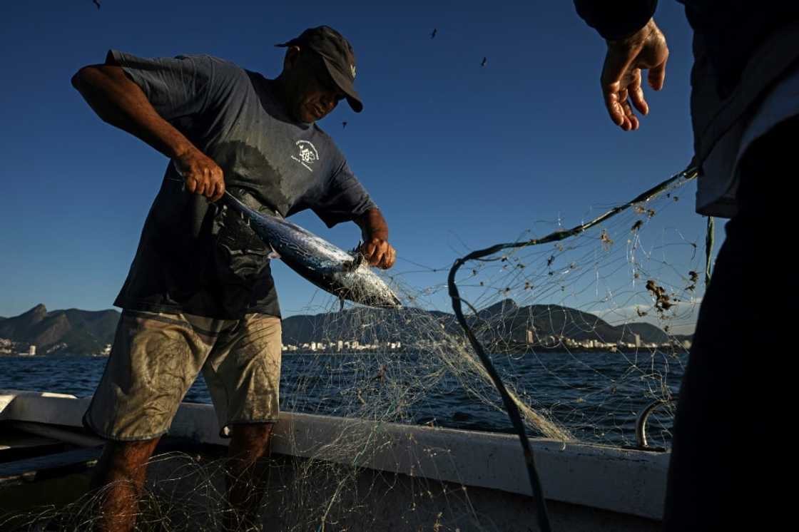 Fishermen ply the waters off Copacabana beach in Rio de Janeiro, Brazil