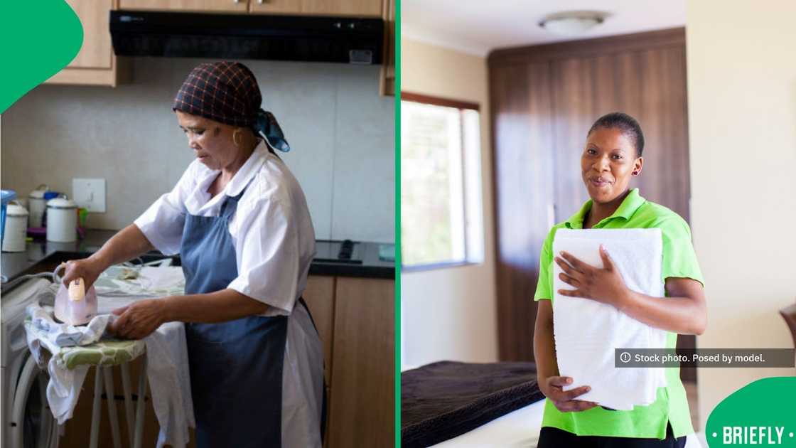 A smiling domestic worker holding a stack of clean white towels in a bedroom on the right A smiling domestic worker holding a stack of clean white towels in a bedroom on the right