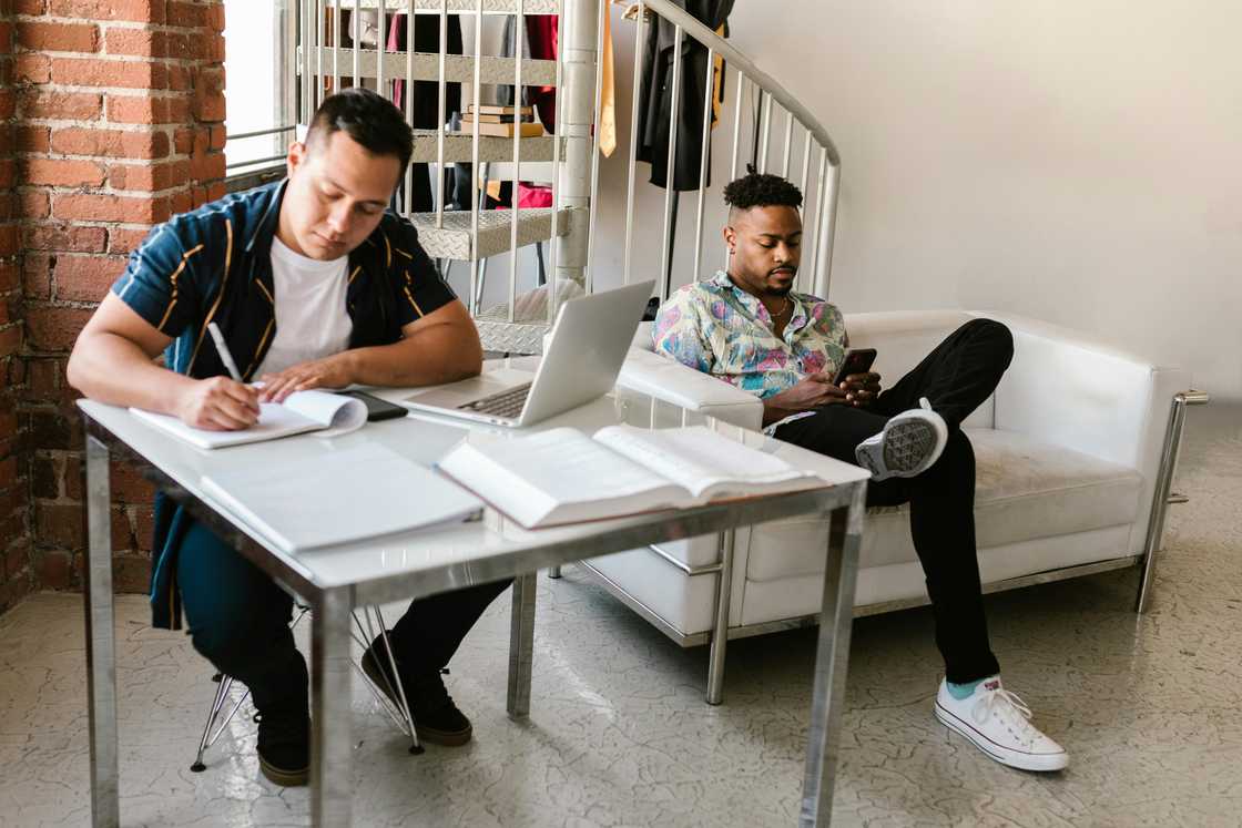 Two multi-ethnic male students are pictured inside their college room