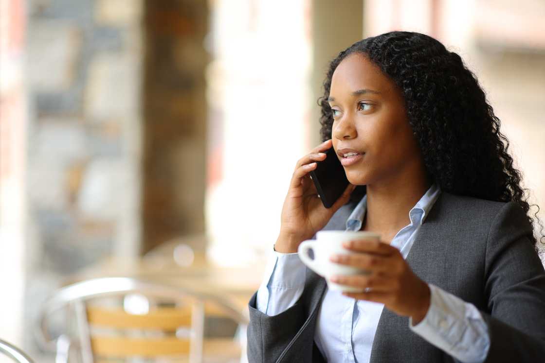 A lady is taling on the phone at a cafe A lady is taling on the phone at a cafe