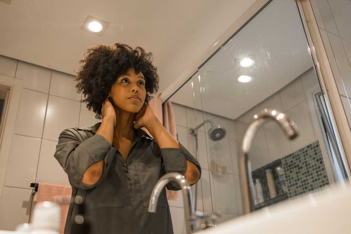 Woman staring at herself in a restaurant bathroom mirror.