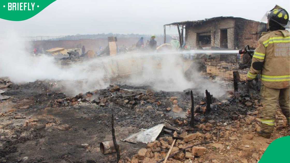 A firefighter attempts to put out the blaze that destroyed 800 homes at the Cemetery View informal settlement.